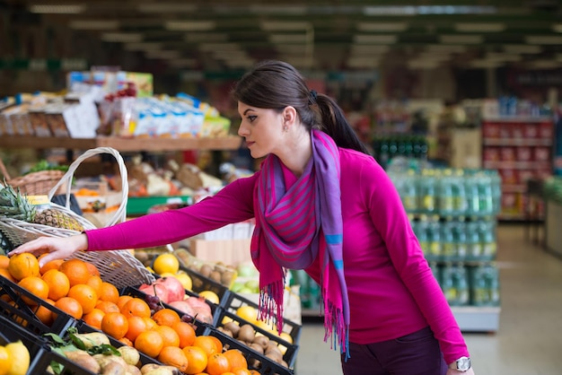 Hermosa mujer joven para compras de frutas y verduras en el departamento de producción de una tienda de abarrotes Supermercado Profundidad superficial de campo