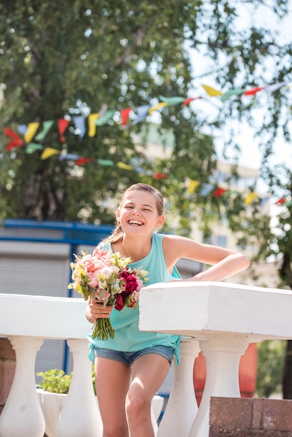 Hermosa mujer joven en una corona de flores con una lila de flores sobre la cara