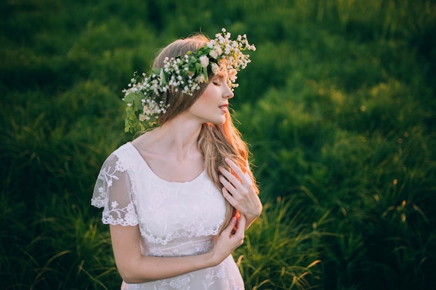 Hermosa mujer joven con corona de flores silvestres en el pelo.