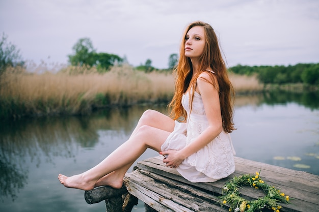 Hermosa mujer joven con corona de flores silvestres