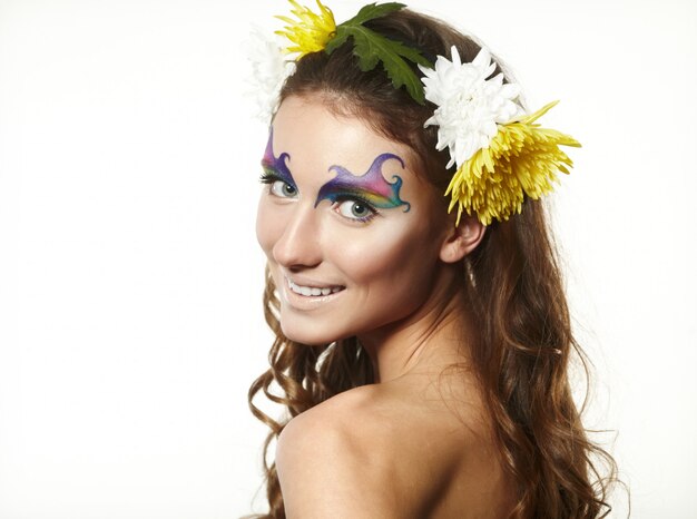 Hermosa mujer joven con delicadas flores en el pelo