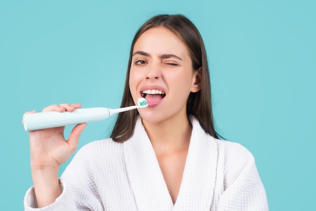 Hermosa mujer joven con dientes sanos hermosa sonrisa femenina Cepillo de dientes eléctrico El primer plano de una mujer joven sostiene un cepillo de dientes