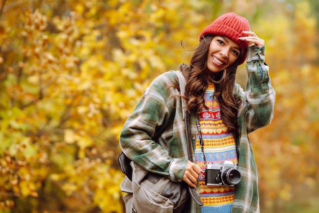 Hermosa mujer joven es fotografiada con cámara retro Concepto de estilo de vida de viaje de relajación de descanso