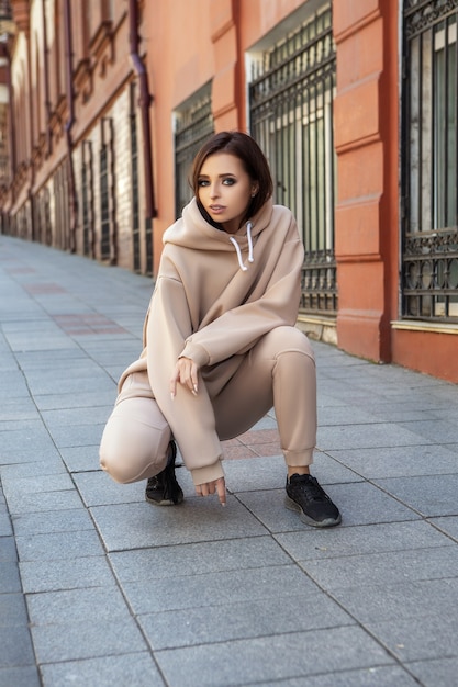 Hermosa mujer joven está posando en un traje de deporte casual