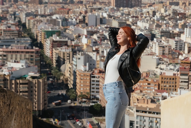 Foto hermosa mujer joven y feliz disfruta de las vistas de la ciudad