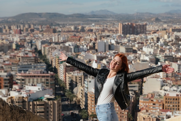 Hermosa mujer joven y feliz disfruta de las vistas de la ciudad