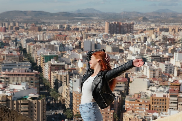 Foto hermosa mujer joven y feliz disfruta de las vistas de la ciudad