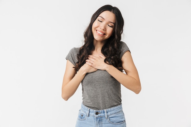 una hermosa mujer joven feliz emocionada posando aislada sobre la pared blanca.