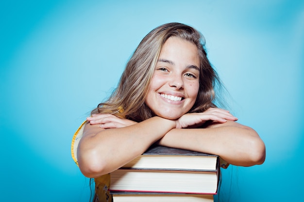 Hermosa mujer joven feliz con libros