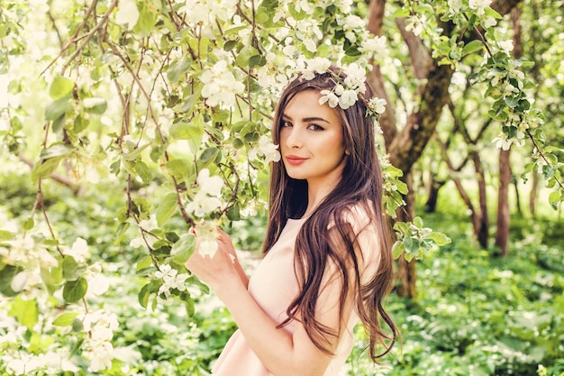 Hermosa mujer joven en flor primavera flores jardín fondo