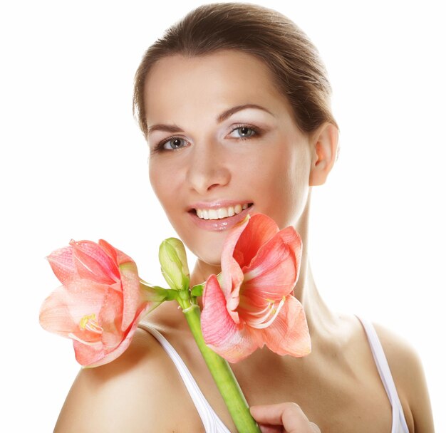 Hermosa mujer joven con flor rosa sobre fondo blanco