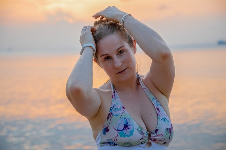 Hermosa mujer joven en el fondo del atardecer junto al mar
