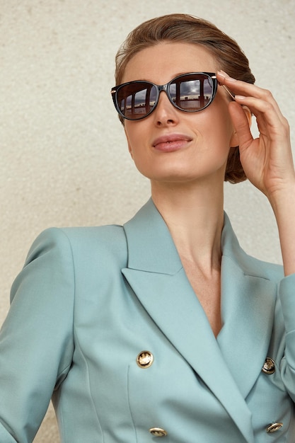 Hermosa mujer joven con gafas de sol en una chaqueta de moda camina por la ciudad Retrato de estilo de vida al aire libre