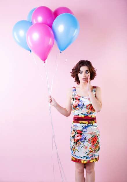 Hermosa mujer joven con globos de colores