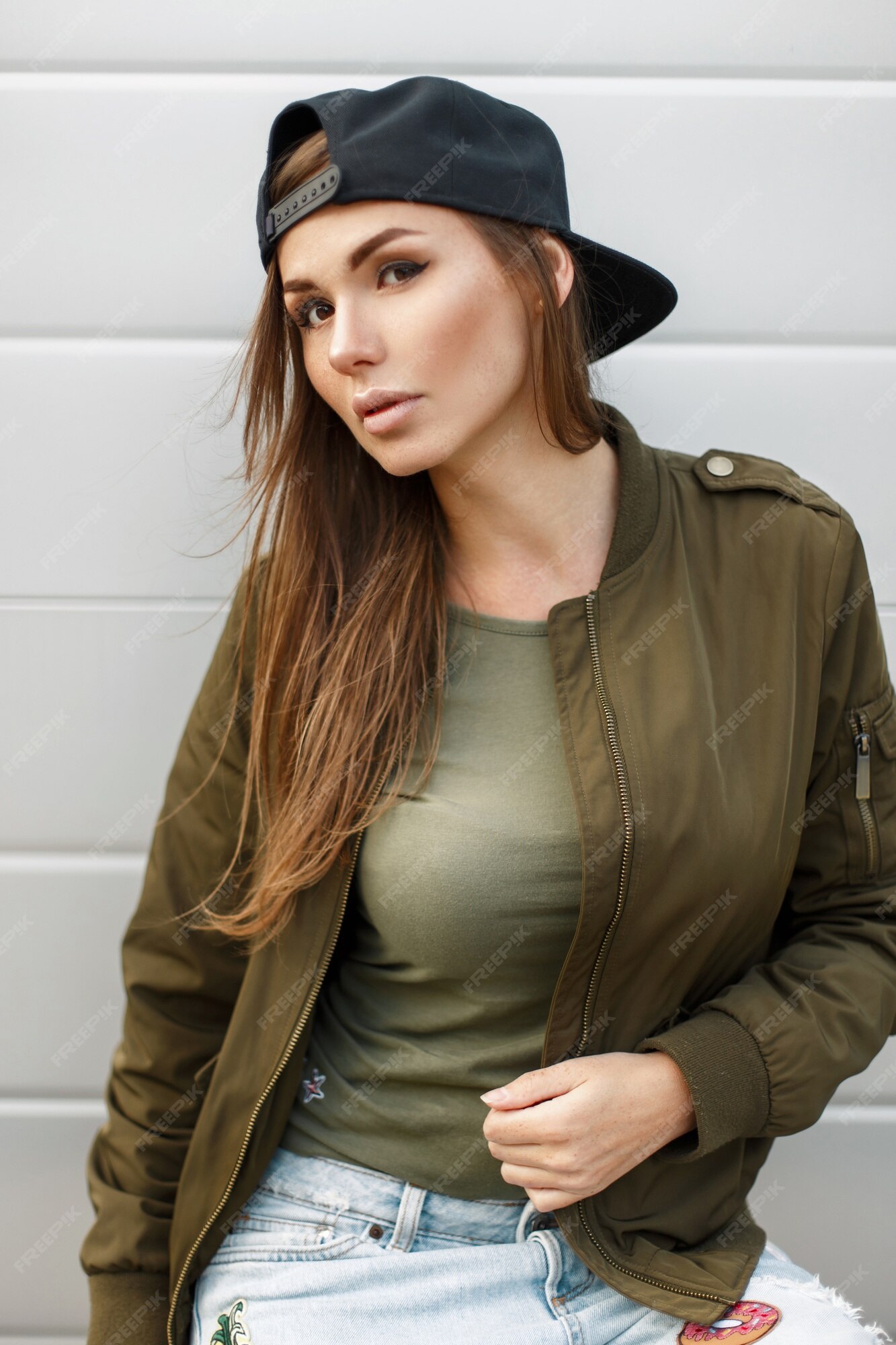 crimen La ciudad película Hermosa mujer joven con una gorra de béisbol en una chaqueta militar verde  | Foto Premium