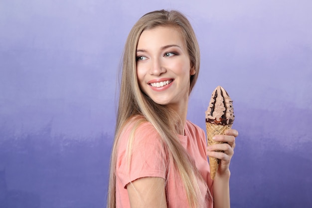 Hermosa mujer joven con helado en violeta