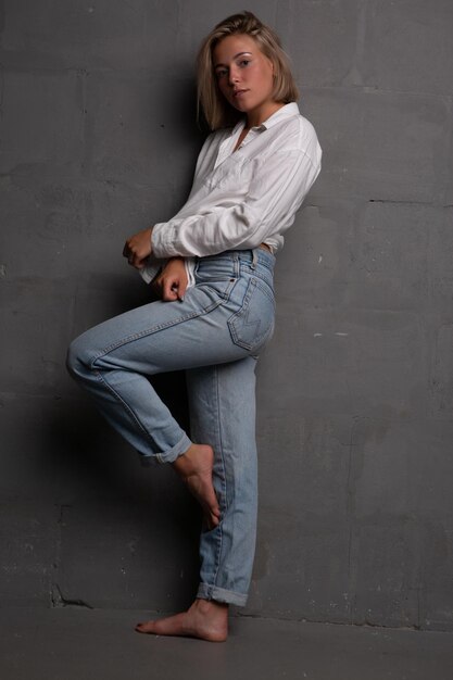 una hermosa mujer joven con una hermosa figura en jeans y una camisa desabrochada