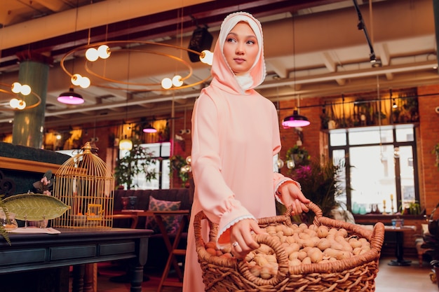 Hermosa mujer joven con un hijab rosa.