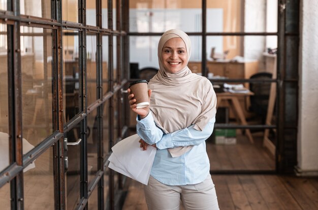 Hermosa mujer joven con hijab trabajando en la oficina