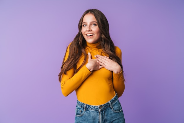 Hermosa mujer joven con largo cabello castaño sonriendo y expresando deleite aislado