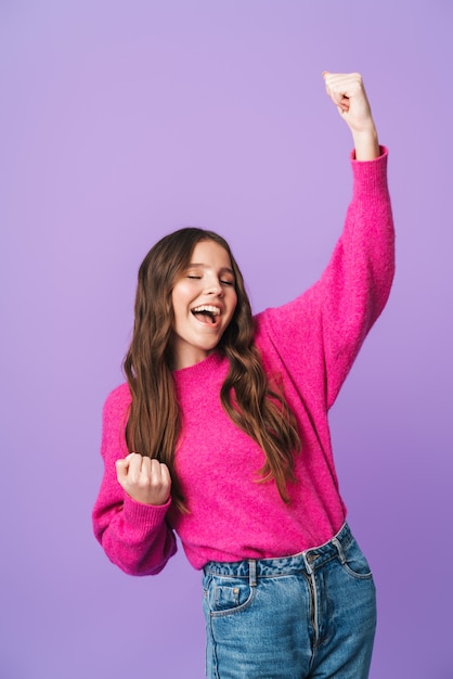 Foto hermosa mujer joven con largo cabello castaño sonriendo y regocijándose como ganador aislado