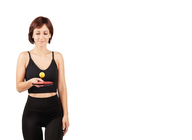 Hermosa mujer joven en mallas negras y top haciendo deporte y yoga en el interior