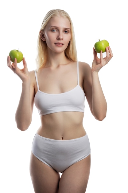 Hermosa mujer joven con manzana verde de cerca en la pared blanca