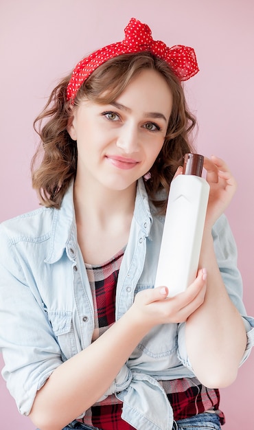 Hermosa mujer joven con maquillaje pin-up y peinado con herramientas de limpieza