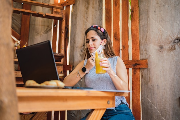 Hermosa mujer joven con máscara protectora en un bar.