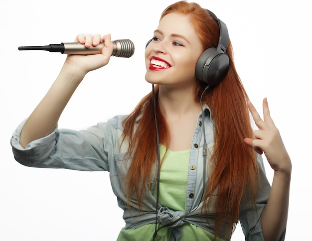 Hermosa mujer joven con micrófono y auriculares