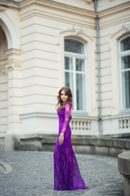 Hermosa mujer joven morena con vestido y caminando en la calle