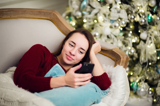 Foto hermosa mujer joven en navidad en casa