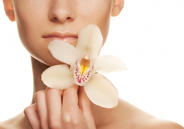 Hermosa mujer joven con orquídea blanca