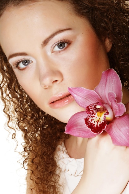 Hermosa mujer joven con orquídea rosa