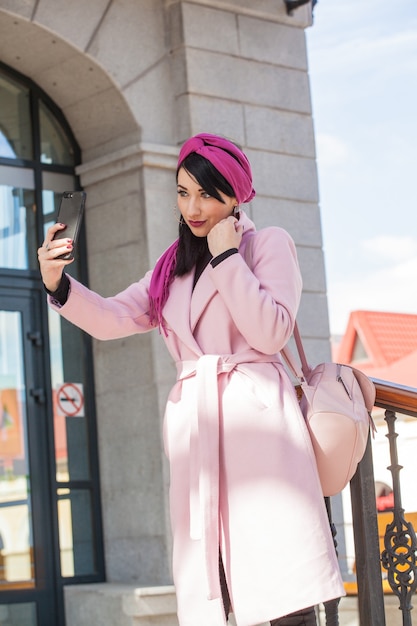 Hermosa mujer joven en un paseo hablando por teléfono