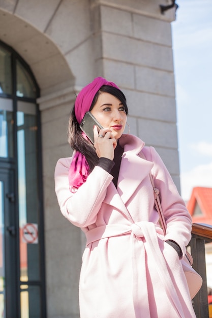 Hermosa mujer joven en un paseo hablando por teléfono