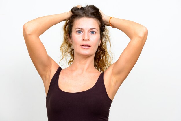 Foto hermosa mujer joven con pelo rubio rizado sobre blanco