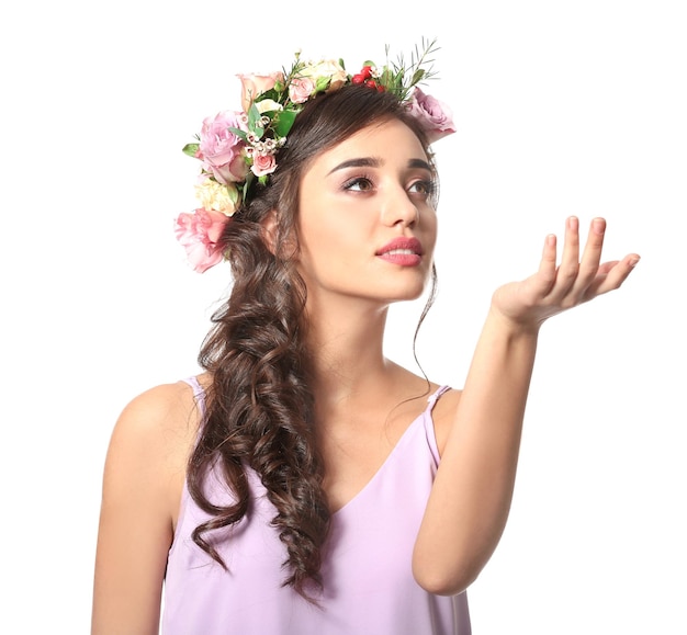 Hermosa mujer joven con perfume floral sobre fondo blanco.