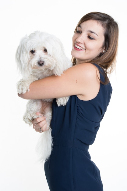 Hermosa mujer joven con un perro blanco