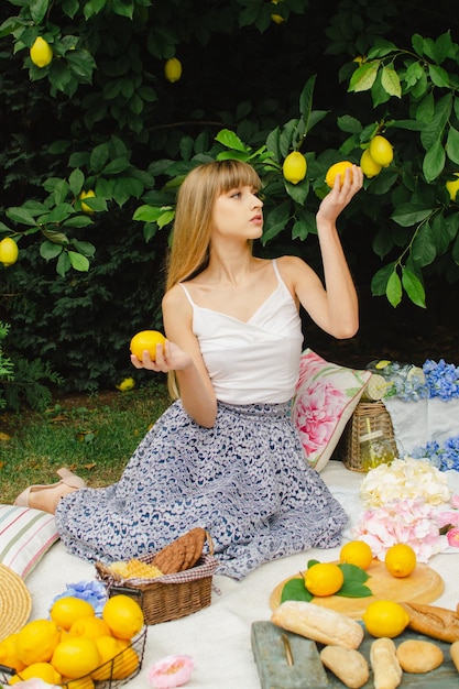 Hermosa mujer joven en un picnic en el jardín