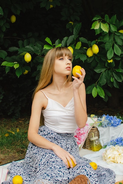 Hermosa mujer joven en un picnic en el jardín