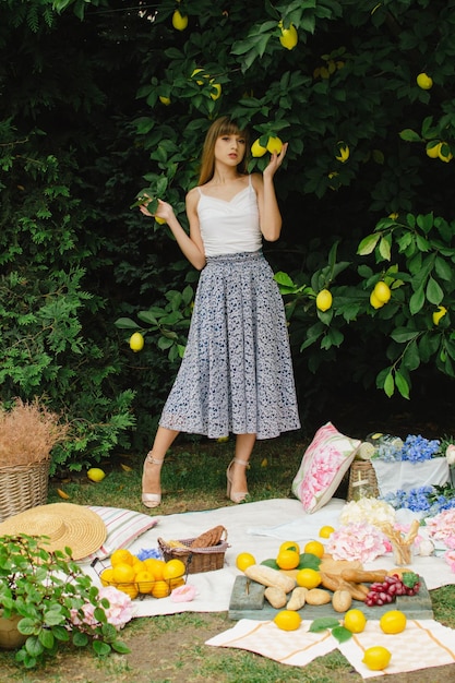 Hermosa mujer joven en un picnic en el jardín