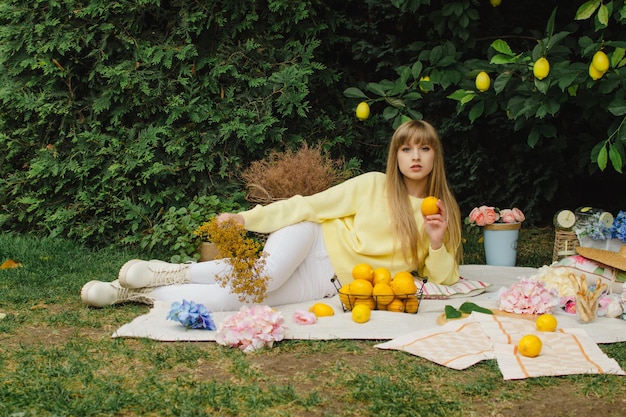 Hermosa mujer joven en un picnic en el jardín