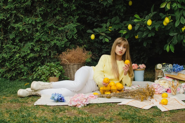 Hermosa mujer joven en un picnic en el jardín