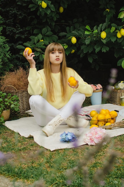 Hermosa mujer joven en un picnic en el jardín