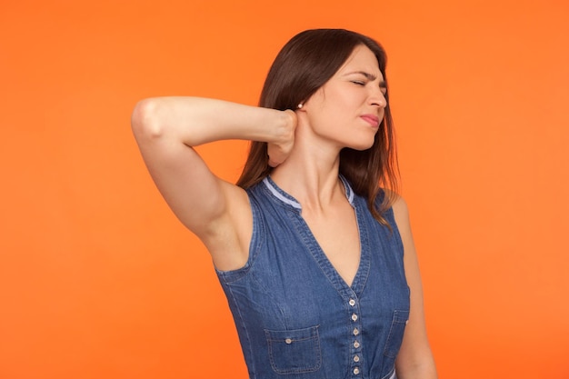 Foto una hermosa mujer joven de pie contra un fondo naranja