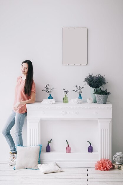 Hermosa mujer joven de pie en una elegante sala de estar decorada