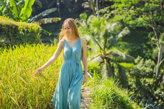 Hermosa mujer joven a pie en la típica ladera asiática con el cultivo de arroz en forma de montaña cascada verde campo de arroz terrazas arrozales Ubud Bali Indonesia Bali concepto de viaje