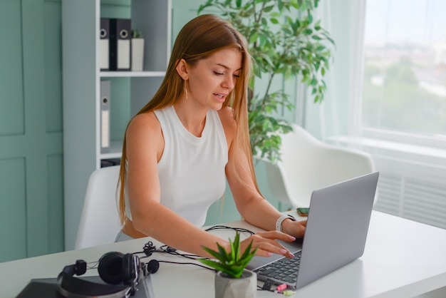 Hermosa mujer joven con un portátil en casa en el sofá charlando estilo de vida online