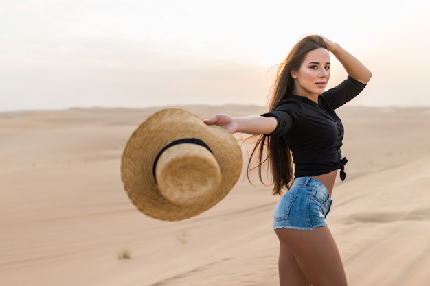 Hermosa mujer joven posando en la arena